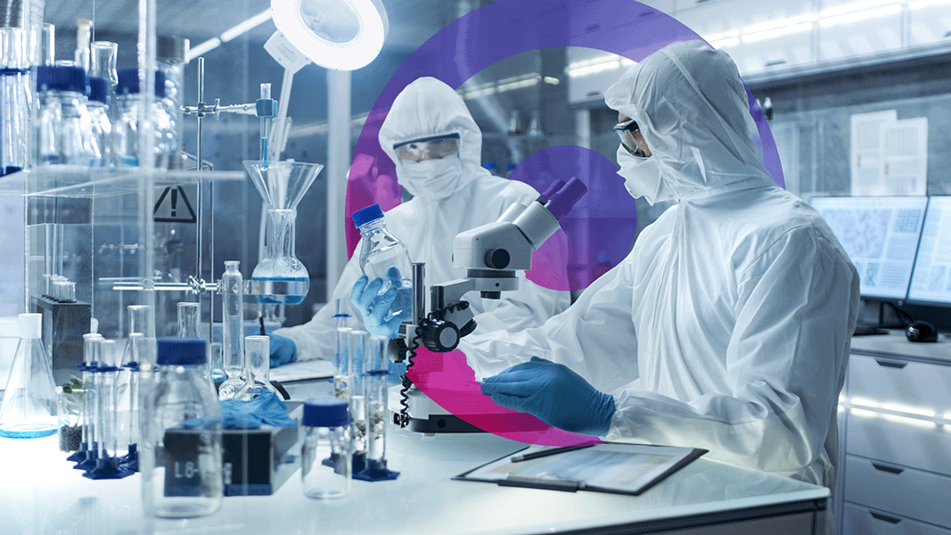 Two people working in a lab looking at tests. There are lots of test tubes on the counter and the 2 individuals are staring at a glass bottle. pink and purple gradient cora lens in the back of image
