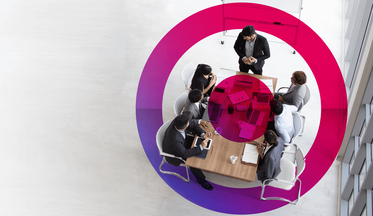 Team of five people having a meeting in an office around a desk. 4 men and 1 woman. Cora systems pink and purple gradient lens in the forefront.