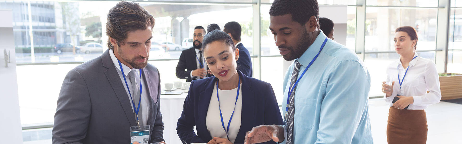 Image at a company expo of three individuals checking out a new product.