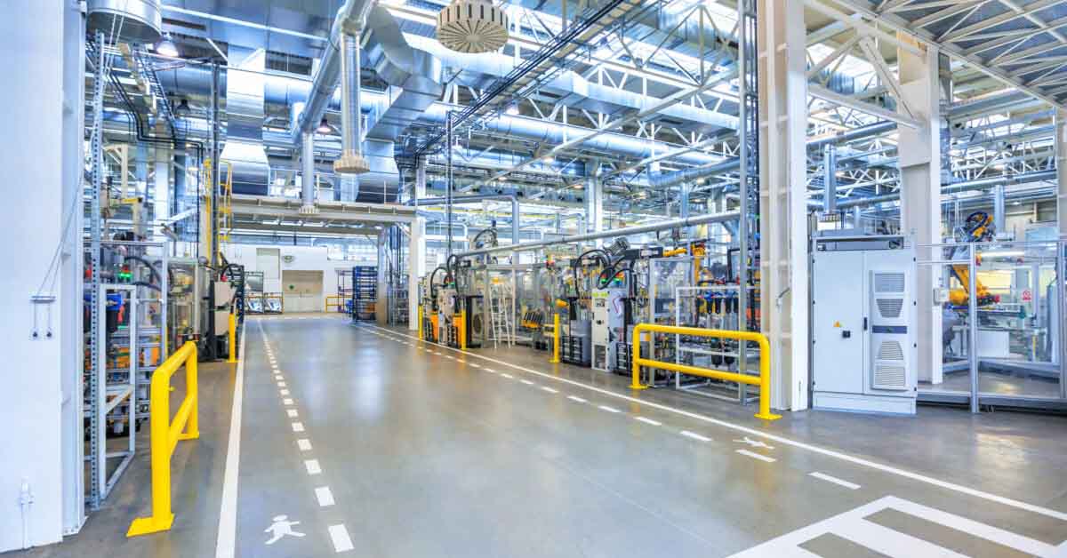 Manufacturing factory with yellow barriers and heavy steel machinery