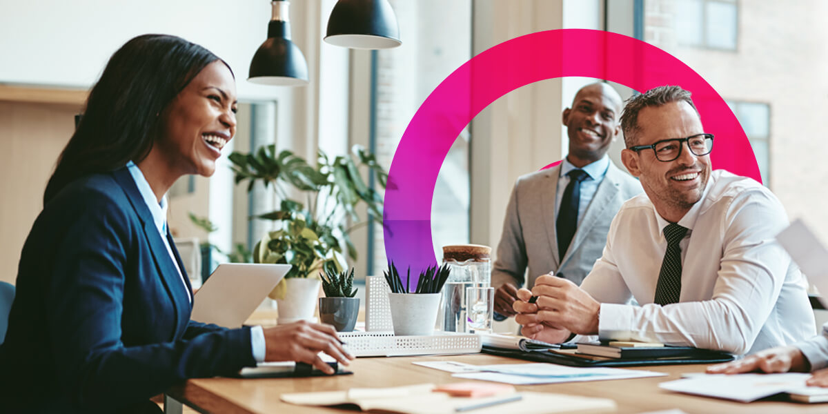 Finance team having a meeting at a table discussing work. The team consists of two men and one woman. Pink and purple lens graphic in the background.