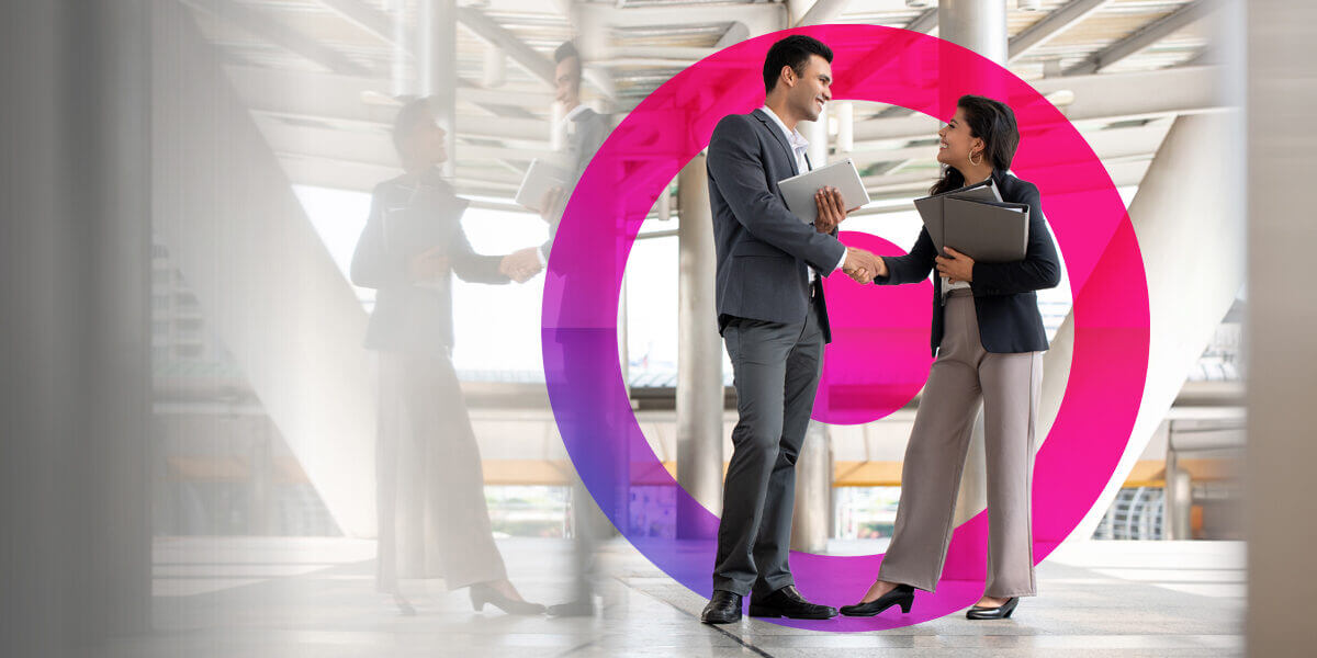 Man and woman in business attire shaking hands.