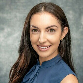 Brown haired woman wearing a navy blouse